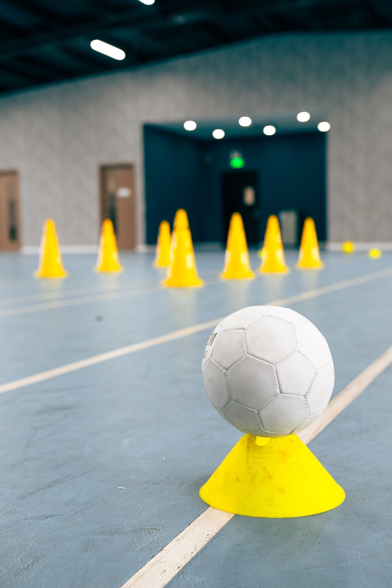 A ball resting on a marker cone with a line of cones set out behind it